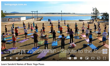 Photo of lots of people on a beach practicing yoga